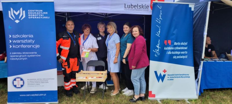 Pracownicy medyczni Wojewódzkiego Szpitala Specialistycznego w Lublinie stojący przy stoisku z materiałami informacyjnymi i punktem mierzenia ciśnienia na dorzynkach wojewódzkich w Świdniku.