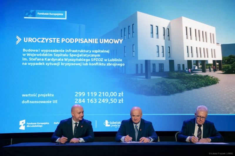 Uroczyste podpisanie umowy na budowę Bloku S. Dokumenty przy stole podpisują od prawej: dyrektor Piotr Matej, marszałek Jarosław Stawiarski oraz trzeci przedstawiciel. W tle duży ekran z wizualizacją nowego budynku