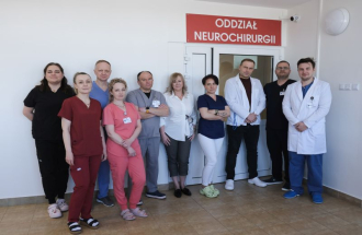 Pracownicy oddziału neurochirurgii na tle wejścia do doodziału
