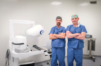 Dr Kedra i dr Kubiak na tle konsoli sterującej robota DaVinci